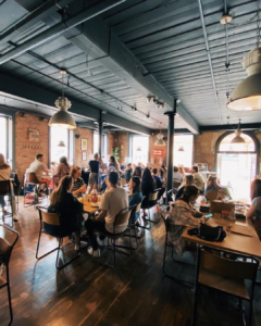 Inside Ezra & Gil in Manchester - a busy coffee shop with an industrial decor.