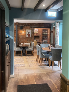 An image showing the restaurant of The Cross Keys pub, with wooden tables and chairs.